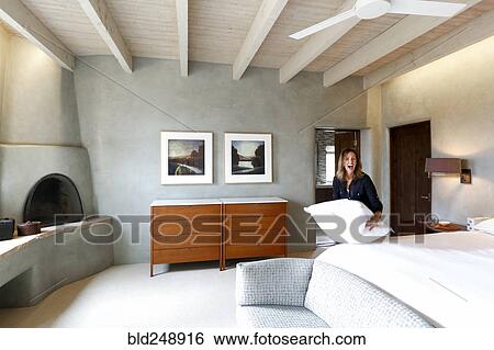 Laughing Caucasian woman holding pillow in bedroom View Large Photo Image Stock Photograph - Laughing Caucasian woman holding pillow in bedroom. Fotosearch