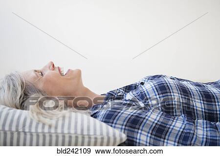 Laughing Caucasian woman laying on pillow View Large Photo Image Stock Photo - Laughing Caucasian woman laying on pillow. Fotosearch