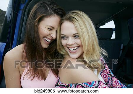 Stock Photography - Laughing Caucasian women in hatch of car. Fotosearch