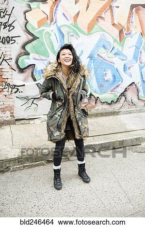 Laughing Mixed Race woman standing near graffiti View Large Photo Image Picture - Laughing Mixed Race woman standing near graffiti. Fotosearch