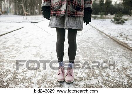 Stock Photo - Legs of Caucasian woman standing in snow. Fotosearch