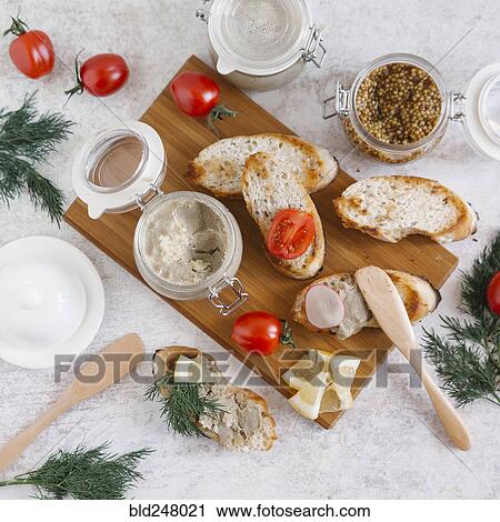 Stock Image - Liver paste and sliced bread on cutting board. Fotosearch