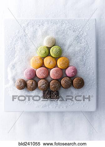 Stock Photography - Macaroons and chocolate in shape of tree on plate with sugar. Fotosearch