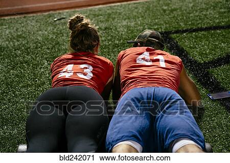 Stock Image - Man and woman laying on artificial turf. Fotosearch