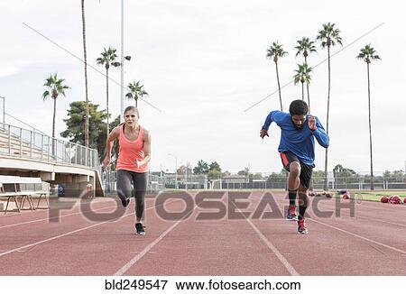 Stock Photo - Man and woman running on track. Fotosearch