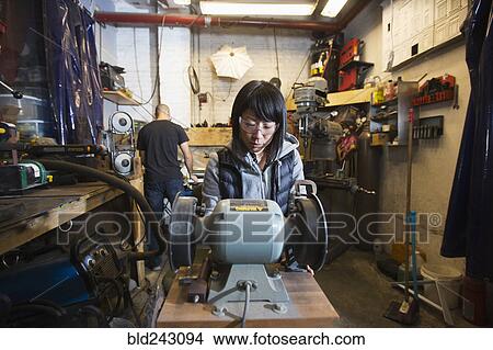 Picture - Man and woman using machinery in workshop. Fotosearch