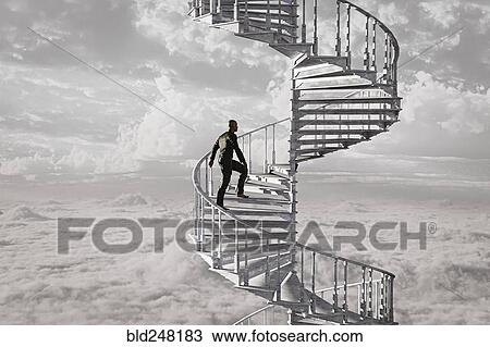 Stock Image - Man climbing spiral staircase in the clouds. Fotosearch