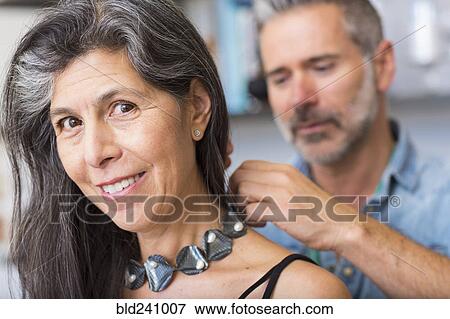 Stock Photo - Man fastening necklace for woman. Fotosearch