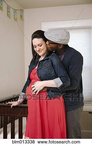 Stock Photo - Man hugging pregnant wife. Fotosearch
