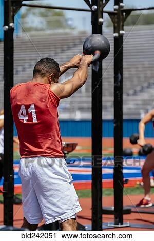 Man lifting kettlebell outdoors View Large Photo Image Stock Image - Man lifting kettlebell outdoors. Fotosearch