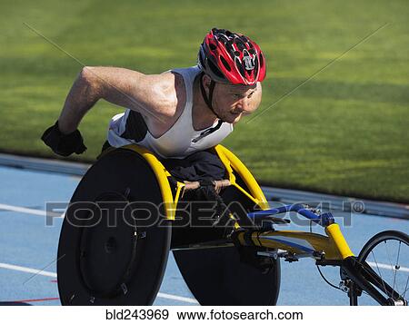 Stock Photo - Man racing in wheelchair on track. Fotosearch