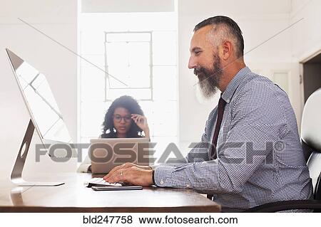 Man using computer desk View Large Photo Image Stock Photo - Man using computer desk. Fotosearch