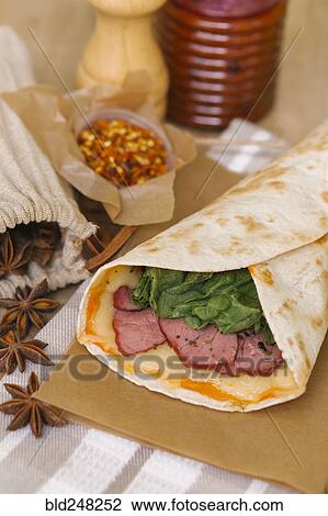 Stock Image - Meat and melted cheese in wrap. Fotosearch