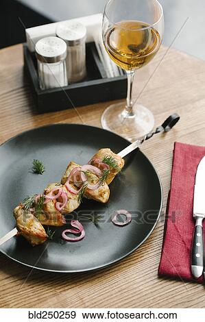 Stock Photo - Meat on skewer with onions and white wine . Fotosearch