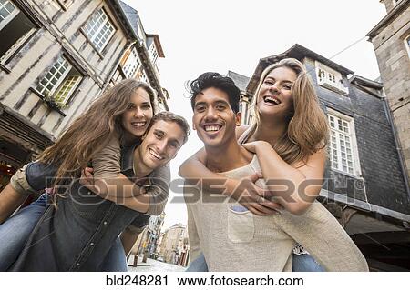 Men carrying women piggyback in city View Large Photo Image Stock Image - Men carrying women piggyback in city. Fotosearch