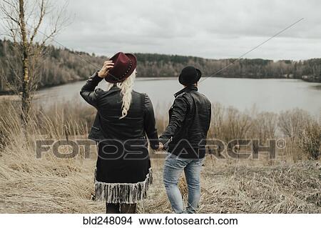 Picture - Middle Eastern couple holding hands near lake. Fotosearch