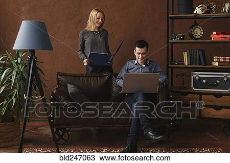 Stock Image - Middle Eastern couple using laptop in livingroom. Fotosearch