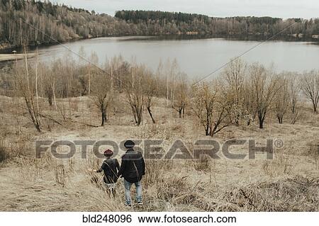 Middle Eastern couple walking on hill near lake View Large Photo Image Stock Photograph - Middle Eastern couple walking on hill near lake. Fotosearch