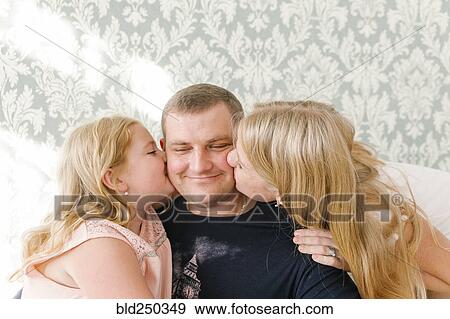 Middle Eastern daughters kissing father on cheek View Large Photo Image Stock Photo - Middle Eastern daughters kissing father on cheek. Fotosearch
