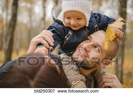 Middle Eastern father carrying baby son in autumn View Large Photo Image Stock Photo - Middle Eastern father carrying baby son in autumn. Fotosearch