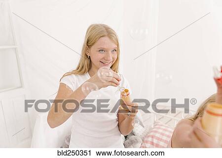 Middle Eastern girl blowing bubbles in bedroom View Large Photo Image Stock Image - Middle Eastern girl blowing bubbles in bedroom. Fotosearch