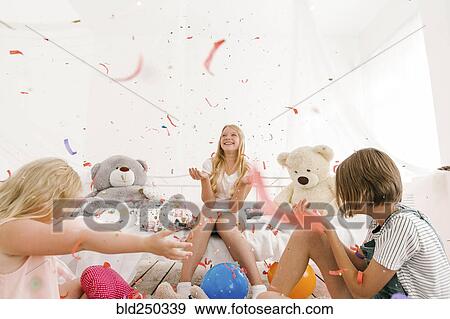 Middle Eastern sisters throwing confetti in bedroom View Large Photo Image Stock Photo - Middle Eastern sisters throwing confetti in bedroom. Fotosearch