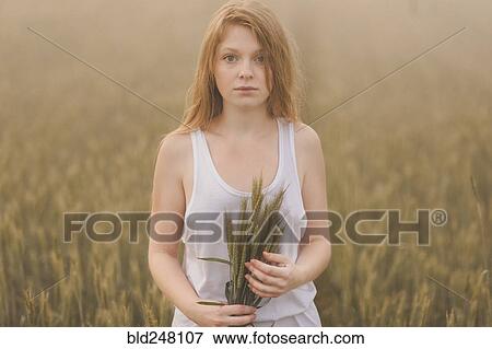 Middle Eastern teenage girl holding wheat in field View Large Photo Image Stock Photo - Middle Eastern teenage girl holding wheat in field. Fotosearch