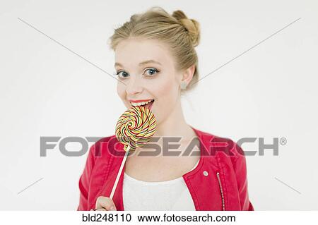 Stock Image - Middle Eastern woman eating lollipop. Fotosearch