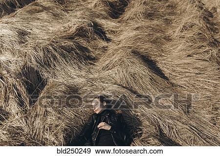 Middle Eastern woman resting in tall grass View Large Photo Image Stock Photo - Middle Eastern woman resting in tall grass. Fotosearch