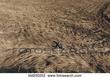 Stock Image - Middle Eastern woman resting on hill. Fotosearch