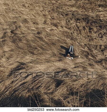 Stock Image - Middle Eastern woman resting on hill. Fotosearch