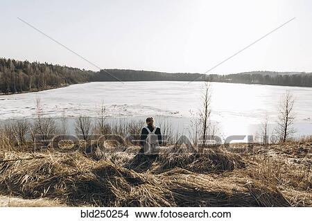 Middle Eastern woman sitting in grass near lake View Large Photo Image Picture - Middle Eastern woman sitting in grass near lake. Fotosearch