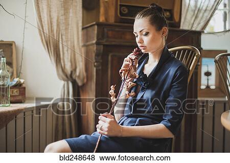 Stock Photo - Middle Eastern woman smelling dried flower. Fotosearch