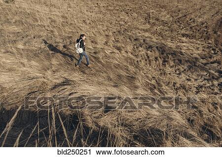 Stock Image - Middle Eastern woman walking on hill. Fotosearch