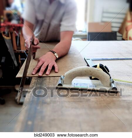 Midsection of Caucasian man cutting panel with saw View Large Photo Image Stock Image - Midsection of Caucasian man cutting panel with saw. Fotosearch