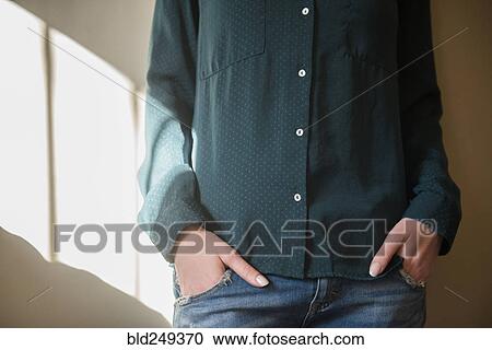 Stock Image - Midsection of Caucasian woman with hands in pockets. Fotosearch