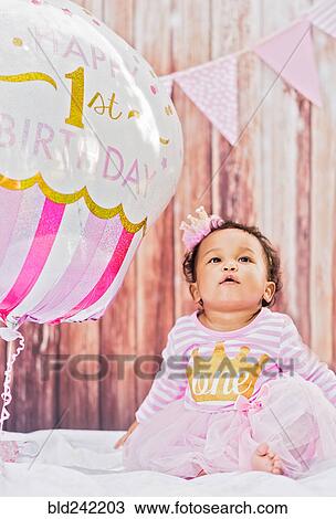 Mixed Race baby girl sitting near birthday balloon View Large Photo Image Stock Image - Mixed Race baby girl sitting near birthday balloon. Fotosearch