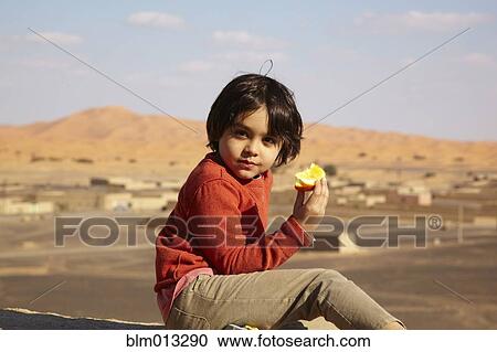 Mixed race boy eating fruit View Large Photo Image Stock Image - Mixed race boy eating fruit. Fotosearch