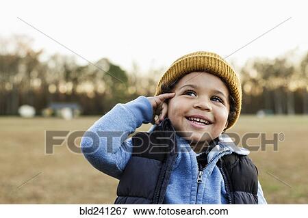 Stock Photo - Mixed Race boy gesturing telephone in park. Fotosearch