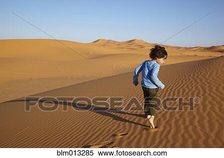 Mixed race boy running in desert View Large Photo Image Stock Photography - Mixed race boy running in desert. Fotosearch