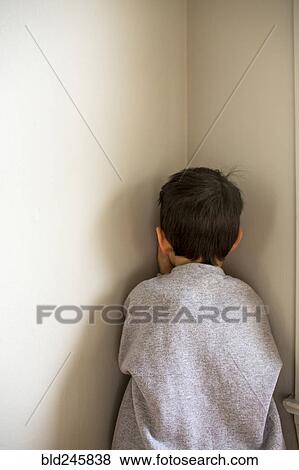 Stock Photo - Mixed Race boy standing in corner. Fotosearch