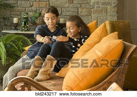 Mixed Race brother and sister reading book on sofa View Large Photo Image Stock Photo - Mixed Race brother and sister reading book on sofa. Fotosearch