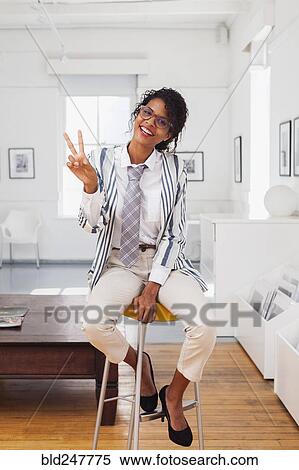 Stock Photography - Mixed Race businesswoman gesturing peace. Fotosearch