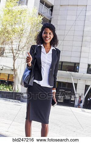 Mixed Race businesswoman gesturing thumbs up outdoors View Large Photo Image Stock Photograph - Mixed Race businesswoman gesturing thumbs up outdoors. Fotosearch