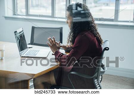 Stock Image - Mixed race businesswoman on video conference. Fotosearch