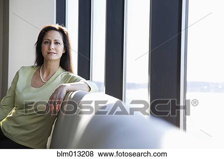 Mixed race businesswoman sitting in lobby View Large Photo Image Stock Photo - Mixed race businesswoman sitting in lobby. Fotosearch