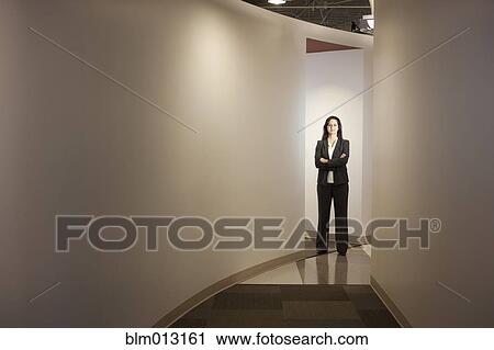 Mixed race businesswoman standing in office hallway View Large Photo Image Stock Image - Mixed race businesswoman standing in office hallway. Fotosearch