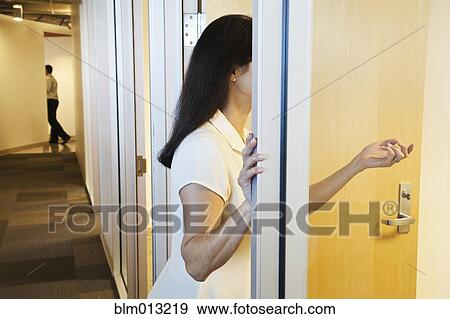 Stock Photo - Mixed race businesswoman standing in office doorway. Fotosearch