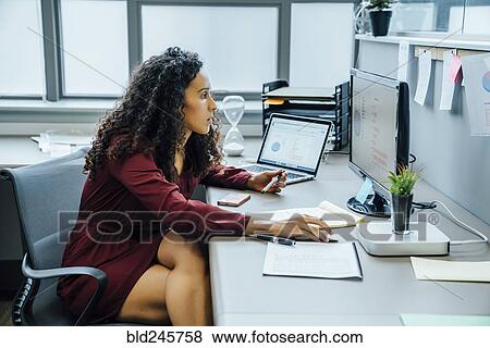 Mixed race businesswoman using computer in office View Large Photo Image Stock Photo - Mixed race businesswoman using computer in office. Fotosearch