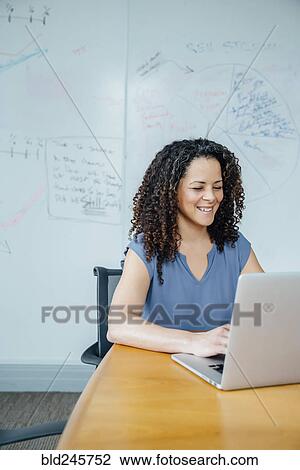 Mixed race businesswoman using laptop View Large Photo Image Stock Image - Mixed race businesswoman using laptop. Fotosearch